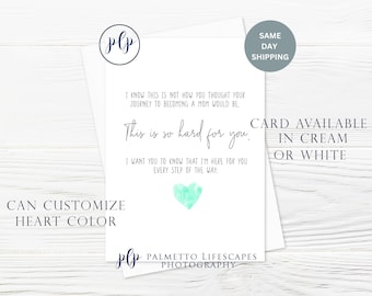 May include: A white card with a blue heart and the text "This is so hard for you."  The card also says "I know this is not how you thought your journey to becoming a mom would be. I want you to know that I'm here for you every step of the way."