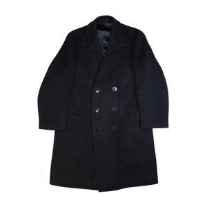 Puede incluir: Un abrigo de lana negro de doble botonadura con un diseño clásico.