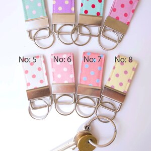May include: Eight colorful key fobs with polka dot patterns. The key fobs are numbered 1 through 8. The key fobs are attached to silver key rings. The key fobs are on a white background. The text "Stubby Key Fobs" is at the bottom of the image.