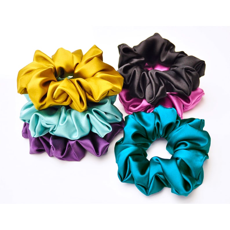 May include: A set of six colorful satin scrunchies in teal, purple, light blue, pink, black, and yellow.