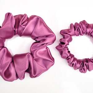 May include: Two purple satin scrunchies, one larger and one smaller.