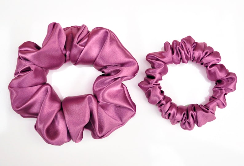 May include: Two purple satin scrunchies, one larger and one smaller.