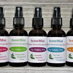 May include: Five brown glass spray bottles of aromatherapy spray, each with a different label color. The labels read "ScentMist" and "My Happy Mist" with various scent names like Vanilla, Peppermint, Lavender, Tea Tree, and Eucalyptus.