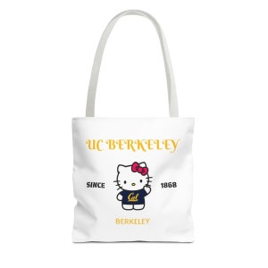 Może przedstawiać: Biała torba typu tote z żółtym logo "UC Berkeley", kreskówkową Hello Kitty w niebieskiej koszulce z żółtym logo "Cal" oraz tekstem "Since 1868" i "Berkeley".