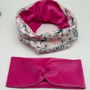 May include: A set of two pink velvet headbands. One headband is a simple twist style, while the other is a wider band with a floral print on the outside and pink velvet on the inside.