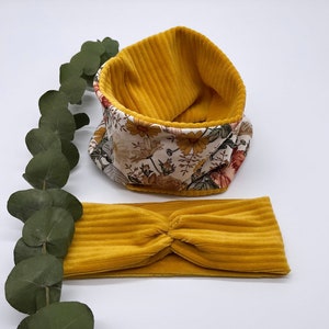 Puede incluir: Una diadema de pana amarilla y un cuello de pana amarilla con forro de estampado floral.