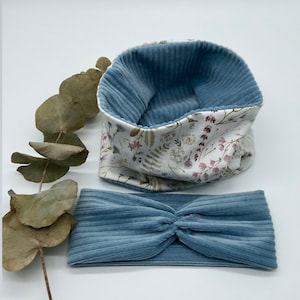 Puede incluir: Un conjunto de dos diademas de pana azul. Una diadema es una banda simple, mientras que la otra es una banda doblada con un forro de estampado floral.