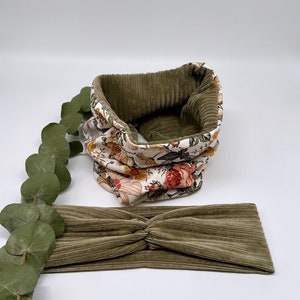 May include: A set of two olive green corduroy headbands. One headband is a simple band, while the other is a cowl neck style with a floral print lining.