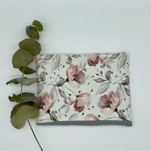 Pode incluir: Uma bolsa branca com um padrão floral com flores e folhas rosa e cinza. A bolsa tem uma borda cinza ao redor das bordas.