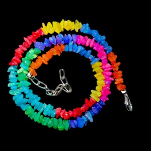May include: A rainbow-colored necklace made of small, irregular gemstone beads. The necklace is strung on a silver chain with a clasp.