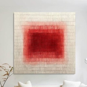 Op de afbeelding: Grote abstracte wandkunst met een gestructureerd, rechthoekig ontwerp en een centrale rode gradiënt. Het kunstwerk staat tegen een neutrale achtergrond en vormt een blikvanger in een moderne woonkamer. Het stuk is boven een witte bank gemonteerd.