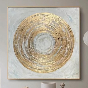 Puede incluir: Pintura abstracta con un gran círculo dorado sobre un fondo blanco. El círculo está formado por anillos concéntricos de pintura dorada.