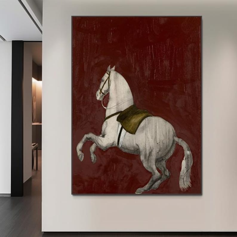 May include: A framed canvas art print featuring a white horse rearing up against a deep red background. The horse has a saddle and bridle, and the artwork has a vintage, textured appearance. The artwork is displayed on a white wall.