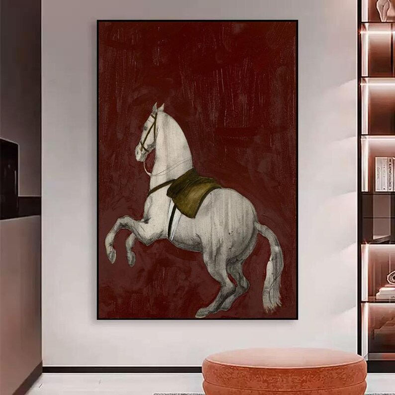 May include: A framed artwork featuring a white horse rearing up against a deep red background. The horse is detailed with a saddle and bridle, and the artwork has a vintage, sketched aesthetic. The piece is a decorative wall art.