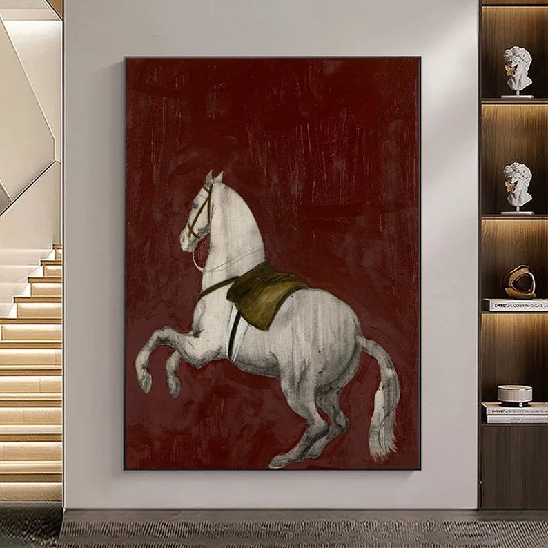 May include: A large canvas print of a rearing white horse with a saddle, set against a deep red background. The artwork has a textured, painterly style, suitable for home decor. The horse is the central focus, with details in shades of gray and brown.