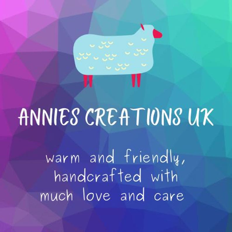 A logo including an illustration of a blue sheep against a pink and green geometric background. The text "ANNIES CREATIONS UK" is below the sheep. The text "warm and friendly, handcrafted with much love and care" is below the text "ANNIES CREATIONS UK".
