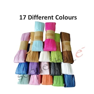 May include: An assortment of 17 different coloured ribbons, each rolled and secured with a brown paper band. The ribbons are in various shades, including pink, blue, and green. Text reads "17 Different Colours".