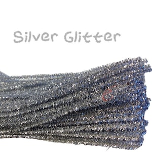 May include: A bundle of silver glitter pipe cleaners. The pipe cleaners are grouped together and have a shiny, metallic finish.