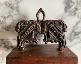 Un interesante dispensador de cigarrillos y fósforos de hierro fundido patentado de estilo victoriano.