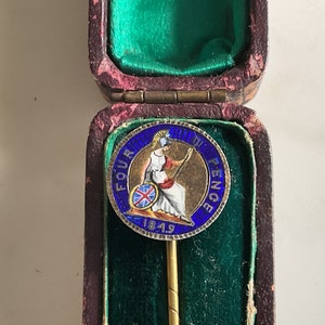 Un'attraente spilla vittoriana con involucro in argento smaltato da quattro pence.