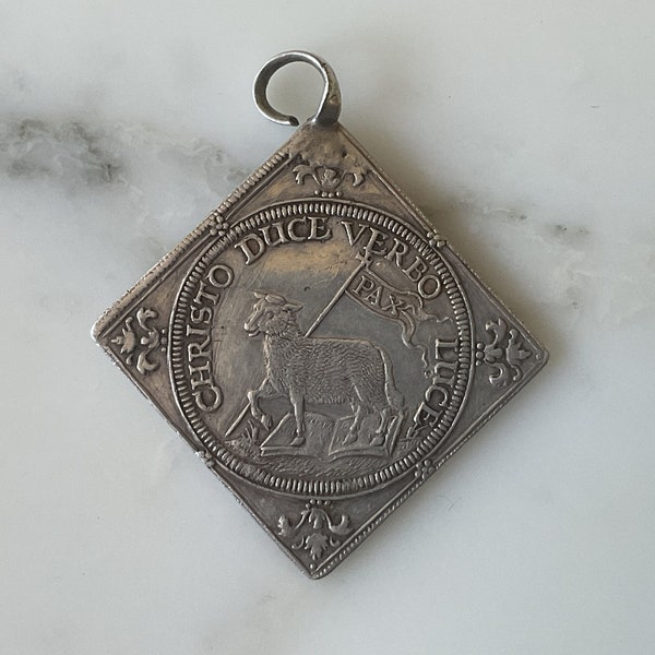 An extraordinary and rare 17th century silver religious commemorative medallion.