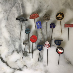 An interesting collection of automotive etc vintage enamel lapel pins.