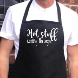 May include: Black apron with white text that reads "Hot stuff coming through".
