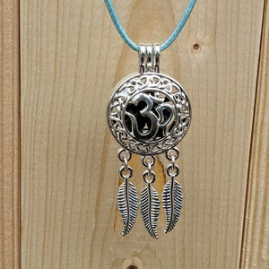 May include: A silver Om charm necklace with a blue cord and four feather charms hanging from the bottom.