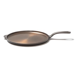 Könnte beinhalten: Eine gusseiserne Grillpfanne mit langem Griff und flacher Kochfläche. Die Pfanne ist dunkelgrau mit einer bronzefarbenen Kochfläche. Der Griff erstreckt sich nach rechts, auf weißem Hintergrund. Dies ist ein Küchenartikel.