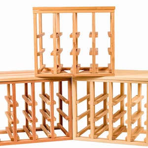 May include: Three wooden wine bottle racks stacked on top of each other. The top rack is a square shape, while the bottom two are rectangular. The racks are made of unfinished wood.