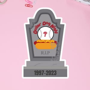 May include: A gray tombstone with the text "Dollar Dog Night" and a baseball with the letter "P" on it. The tombstone also has a hot dog on it and the text "R.I.P." and "1997-2023".