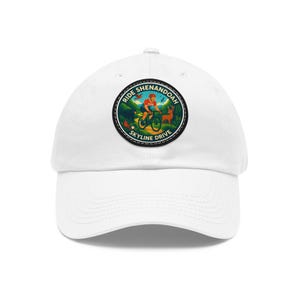 Peut inclure: Casquette de baseball blanche avec un écusson circulaire représentant un cycliste sur un vélo de montagne, un cerf et le texte "Ride Shenandoah Skyline Drive". L'écusson a un code couleur vert, orange et bleu.