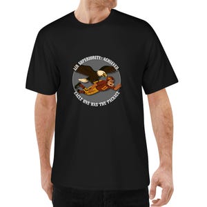 Könnte beinhalten: Schwarzes T-Shirt mit einem kreisförmigen Grafikdesign, das einen Adler und einen Footballspieler zeigt. Der Text lautet: "AIR SUPERIORITY ACHIEVED. EAGLE ONE HAS THE PACKAGE."