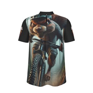 May include: Short-sleeved cycling jersey featuring a cartoon beaver riding a mountain bike through a forest. The jersey has a black collar and sleeves, with a zipper down the front. The beaver is wearing a helmet and knee pads.