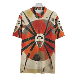 Puede incluir: Camiseta de manga corta con un llamativo diseño abstracto. La camiseta presenta un círculo rojo central con líneas negras que irradian hacia afuera y una forma blanca similar a una cara. La paleta de colores incluye rojo, naranja, negro y crema.