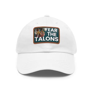 May include: White baseball cap with a curved peak. The cap has a rectangular patch with the text "FEAR THE TALONS" in white letters. The patch also includes an image of bird talons.