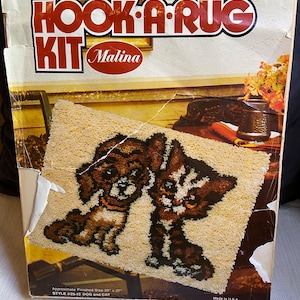 May include: Vintage "Hook-A-Rug Kit" box featuring a dog and cat design. The box reads "Malina" and "Approximate Finished Size 20" x 27". The rug design shows a brown dog and a brown and white cat. Made in the U.S.A.