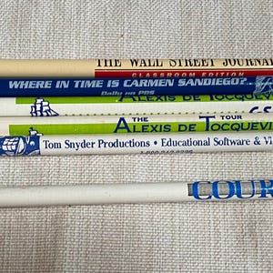 May include: A collection of six promotional pencils featuring various brand names and logos including The Wall Street Journal, Where in Time is Carmen Sandiego, C-SPAN, The Alexis de Tocqueville Tour, Tom Snyder Productions, and Court TV, with assorted erasers.