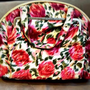 May include: A vintage floral patterned handbag with a metal frame closure and a top handle.