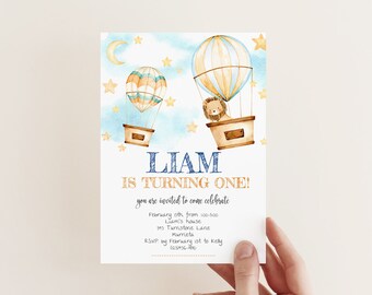 May include: A blue and gold birthday invitation with a watercolor illustration of hot air balloons and stars. The text reads "Liam is turning one!" and includes details about the party, including the date, time, location, and RSVP information.