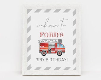 May include: A white framed sign with a red and grey striped background. The sign says "Welcome to Ford's 3rd Birthday!" with a watercolour illustration of a red fire engine.