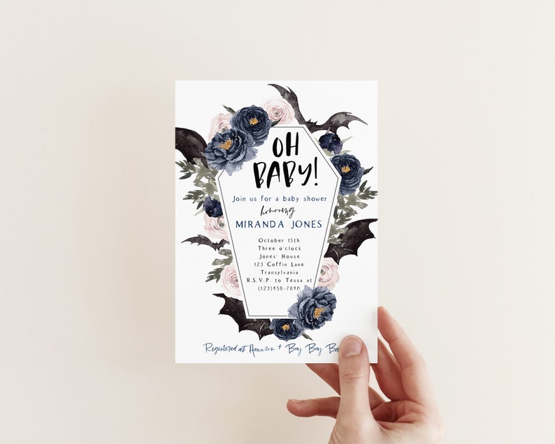 May include: A white baby shower invitation with a black and white coffin design. The coffin is decorated with black bats, pink and blue flowers, and the text "Oh Baby!"  The invitation includes the details for the baby shower, including the date, time, location, and RSVP information.