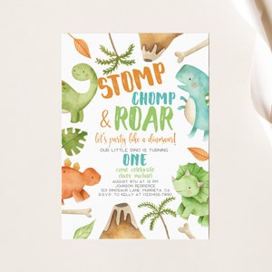May include: A colorful dinosaur-themed birthday party invitation with a green, orange, and blue dinosaur illustration. The text reads "STOMP CHOMP & ROAR let's party like a dinosaur! Our little dino is turning ONE come celebrate Oliver Michael August 8th at 12 PM Johnson Residence 123 Dinosaur Lane Murrieta CA RSVP to Kelly at (123) 456-7890"