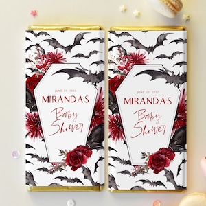 May include: Two white chocolate bar wrappers with a gothic baby shower theme. The wrappers feature black bats, red roses, and the text "Miranda's Baby Shower" with the date "June 20, 2022".