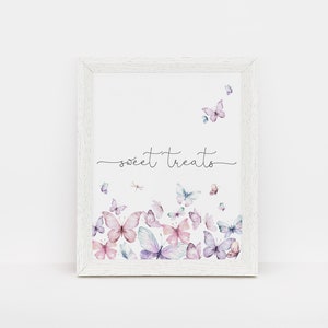 Puede incluir: Una impresi&oacute;n enmarcada en blanco con el texto "sweet treats" en escritura cursiva negra. La impresi&oacute;n presenta un dise&ntilde;o de acuarela de mariposas rosas y moradas.