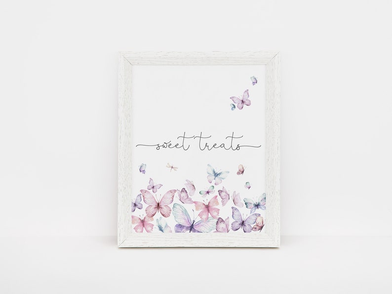 Puede incluir: Una impresi&oacute;n enmarcada en blanco con el texto "sweet treats" en escritura cursiva negra. La impresi&oacute;n presenta un dise&ntilde;o de acuarela de mariposas rosas y moradas.