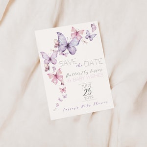 May include: Save the date card with a butterfly theme. The card is white with purple and pink butterflies and the text "Save the Date, Butterfly Kisses & Baby Wishes, July 25, 2022, Cassey's Baby Shower".
