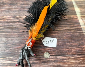 Chicken Foot Talisman – orange, black, and yellow feathers with silver doll charm