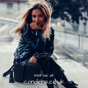 May include: A black leather crossbody bag with a long tassel. The bag has a flap closure with a buckle and an adjustable strap. Visit us at: conders.co.uk