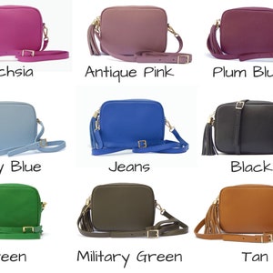 May include: Nine different coloured leather crossbody bags with a gold tassel. The colours are fuchsia, antique pink, plum blush, sky blue, jeans, black, green, military green, and tan.